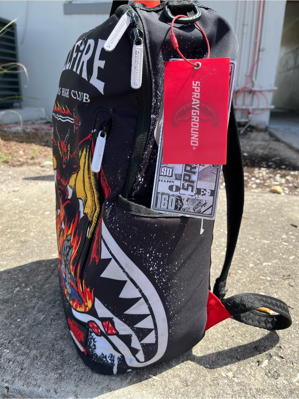 Sprayground Black Backpack with Red Tag and Yellow Flame Graphic